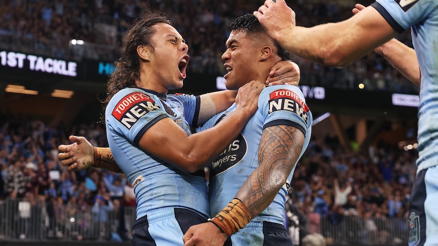 Two NSW State of Origin players celebrate a try 