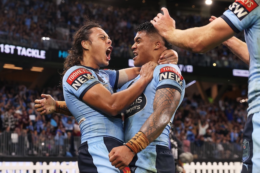 Two NSW State of Origin players celebrate a try 
