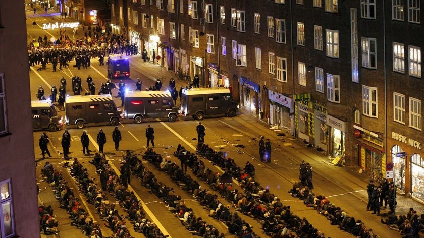 Demonstrators sit on the ground after police rounded them up during a rally