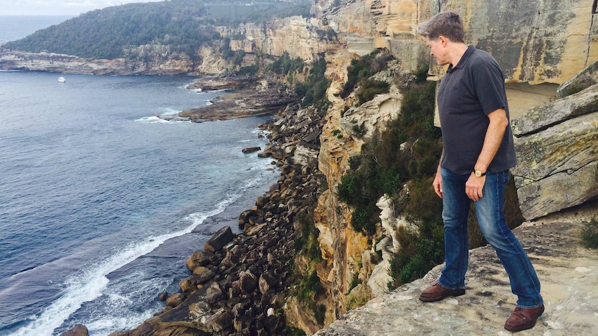 Steve Johnson looks over the cliffs at North Head
