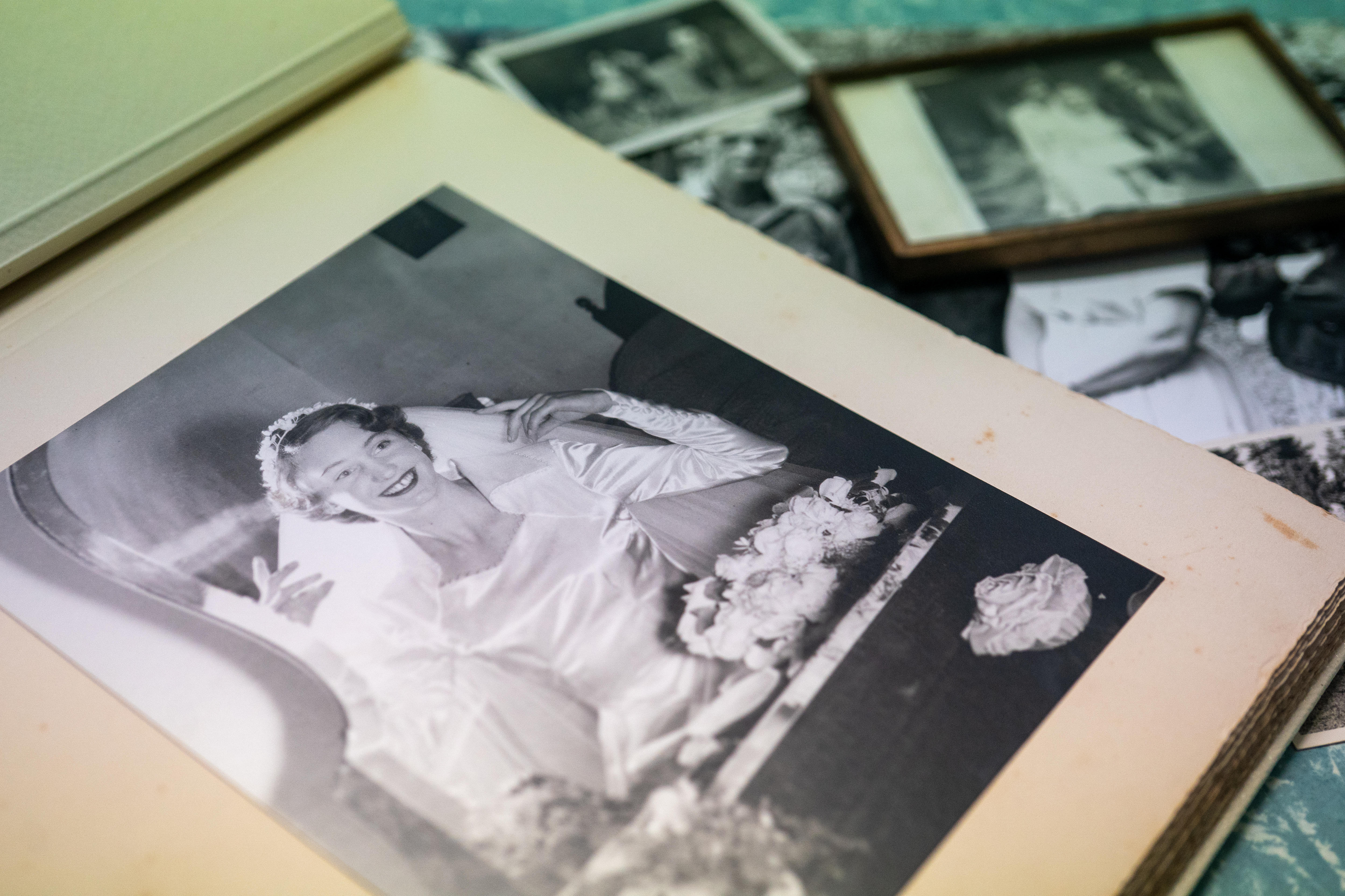 A black and white image of a woman in a wedding dress in a photo album on a table