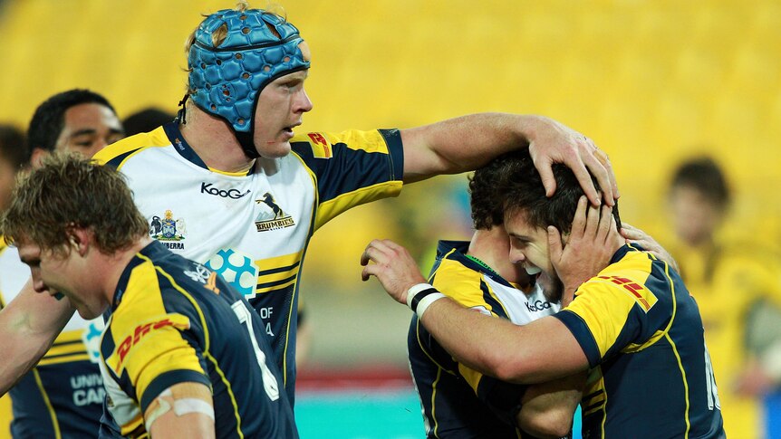 Huge win ... Nic White (C) and Peter Kimlin (L) celebrate Brumbies fly half Zach Holmes' try.