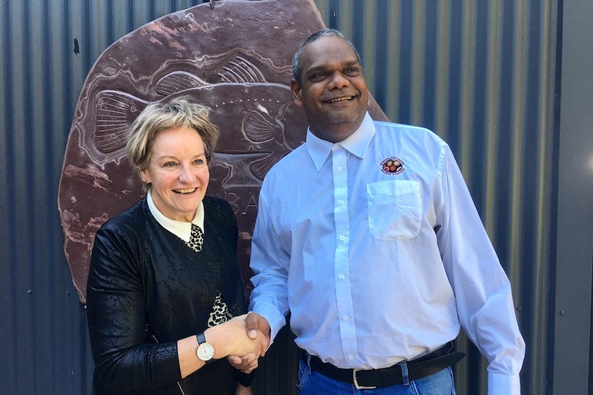 Female Agriculture Minister and male aboriginal leader shake hands