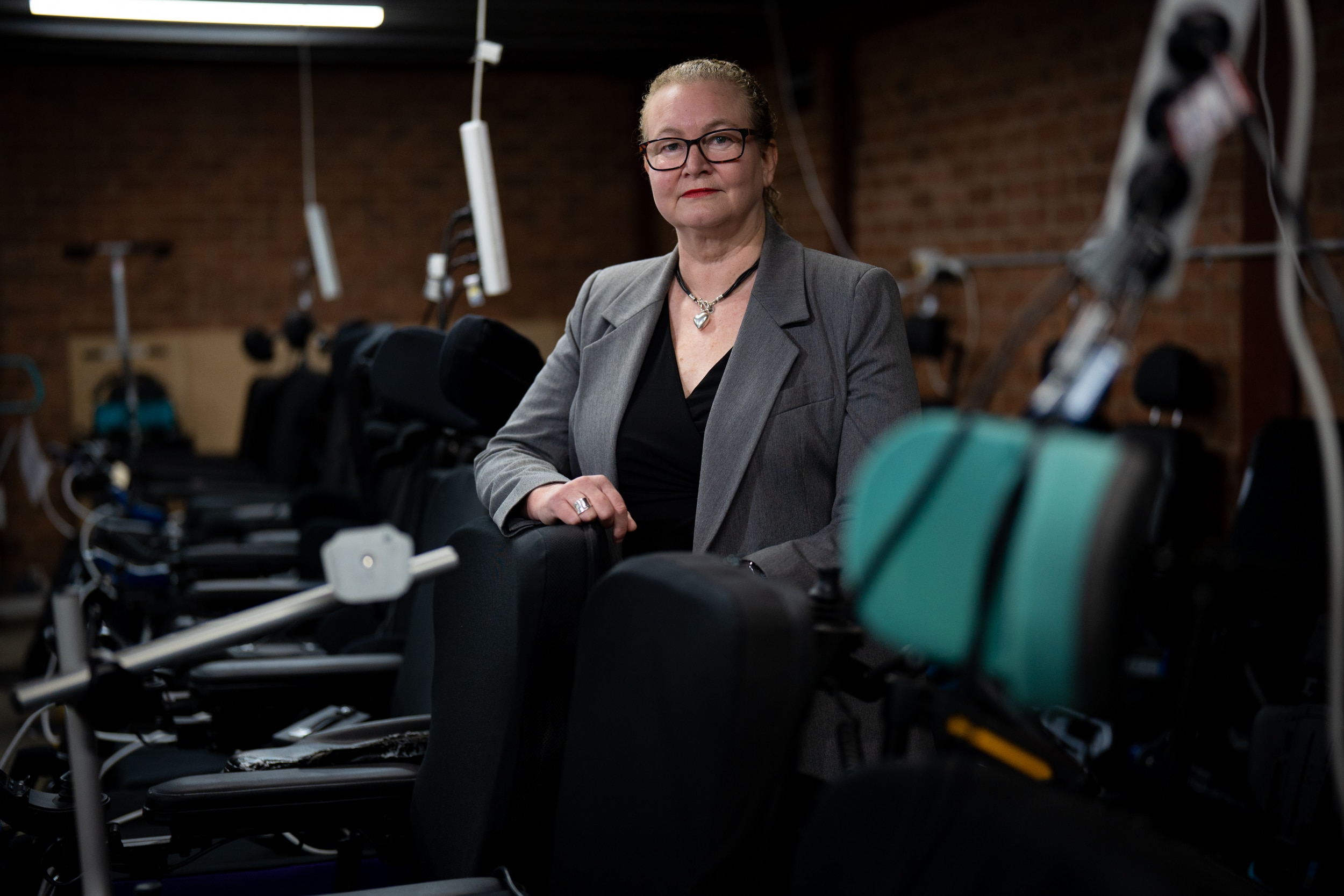 A woman sitting amongst medical support equipment