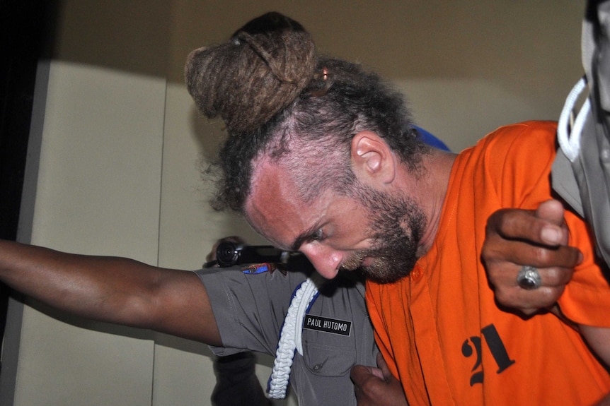 Police take British man David Taylor being taken from his holding cell in Bali