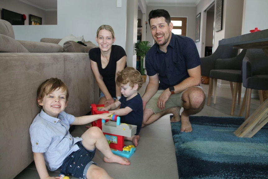 Family of two parents and two small children playing with toys