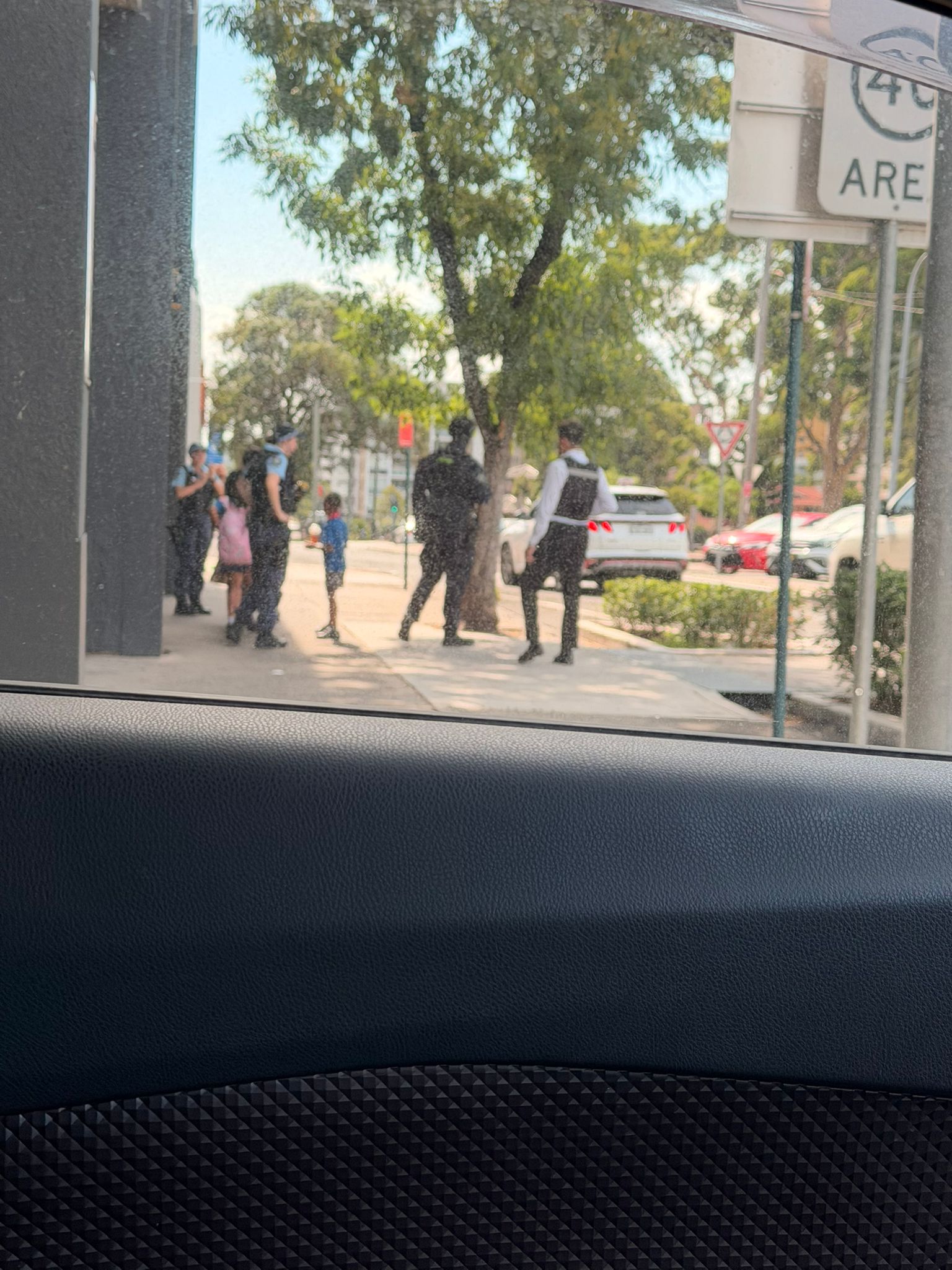 Police speak to witnesses on a suburban street.