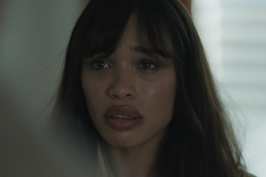 Cleopatra Coleman, a tanned white woman with brown hair and a fringe looks forlorn at a subject off-camera