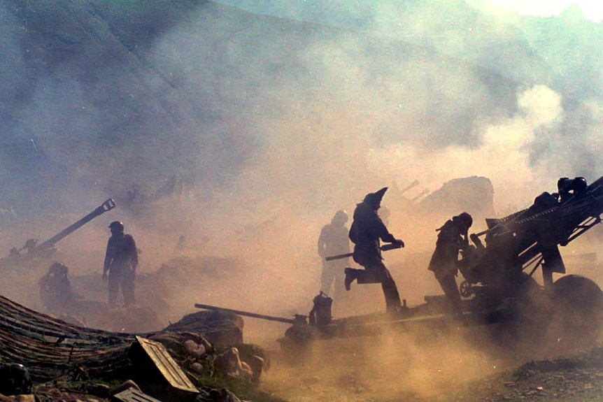 An old photo showing silhouettes of soldiers and weapons against a smoky backdrop 