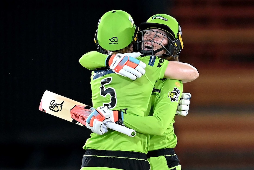 Sydney Thunder batters Rachael Haynes (right) and Heather Knight (facing away from the camera) hug after the WBBL final.