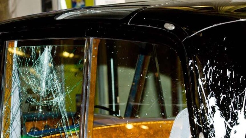 A window is broken and paint is splattered on the royal car