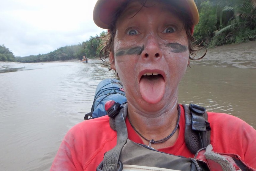 A female kayaker pokes her tongue out while taking a selfie-style photograph on Papua New Guinea's Fly River.