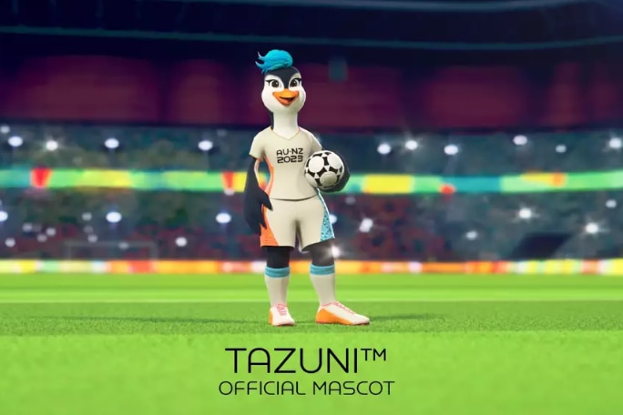 Tazuni the cartoon penguin mascot, wearing a football uniform and holding a football.