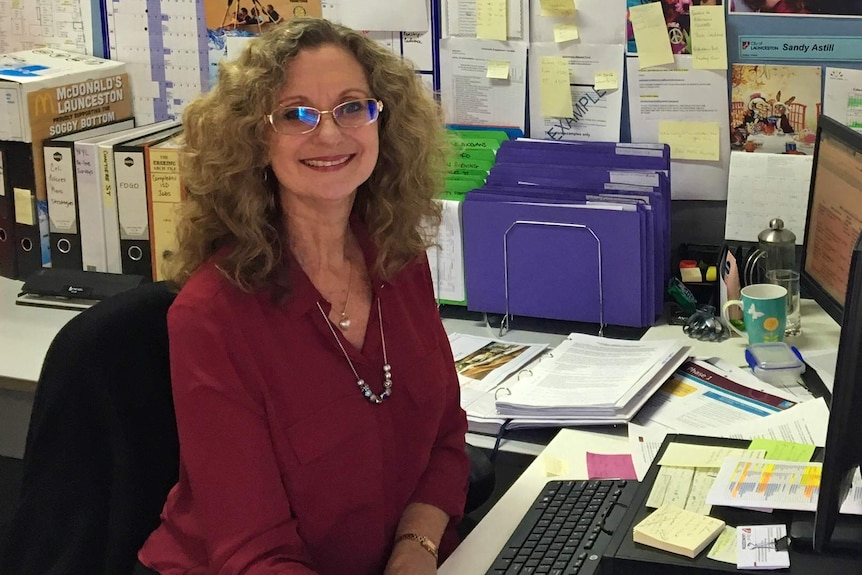 Human geographer Dr Sandy Astill sits at her desk reading documents