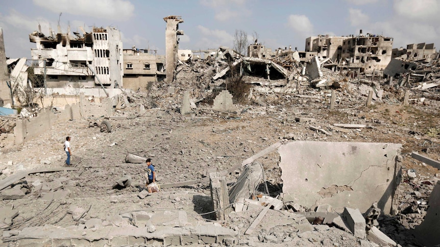 Palestinians inspect destroyed houses and the area where the Al-Wafaa hospital stood in the Al-Shejaea neighbourhood of Gaza City.