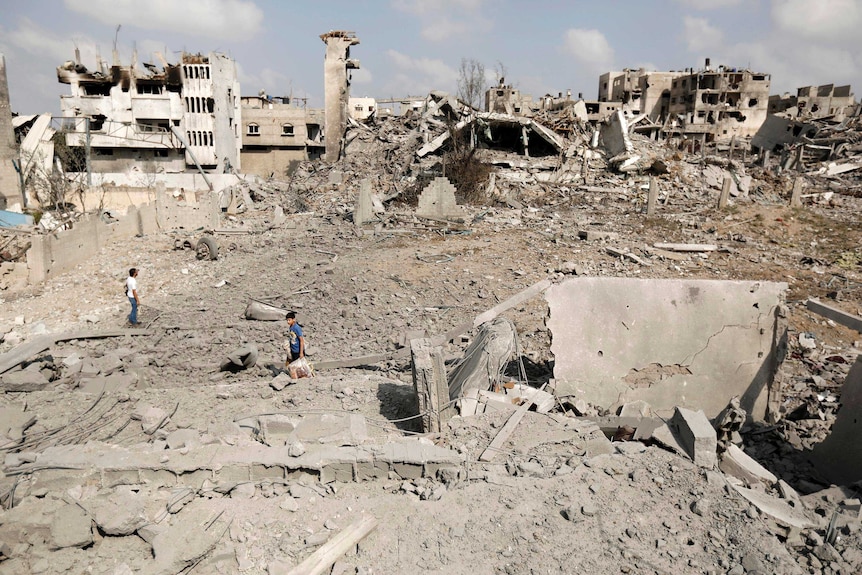 Palestinians inspect destroyed houses and the area where the Al-Wafaa hospital stood in the Al-Shejaea neighbourhood of Gaza City.