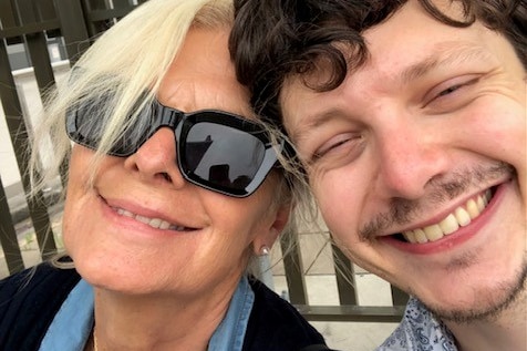 A woman takes a selfie with her adult son