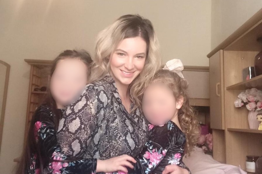 Alana, centre, with her two children whose faces have been blurred.