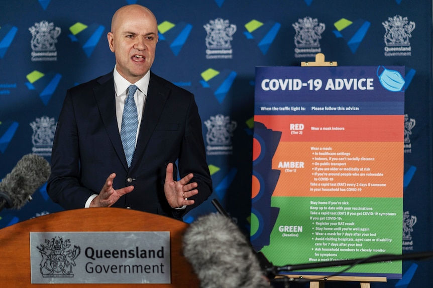 Chief Health Officer John Gerrard standing in front of a sign explaining the rules.