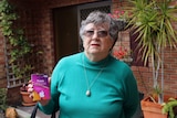 Scam victim Jenni Woodroffe, 80, holds a bundle of iTunes vouchers.