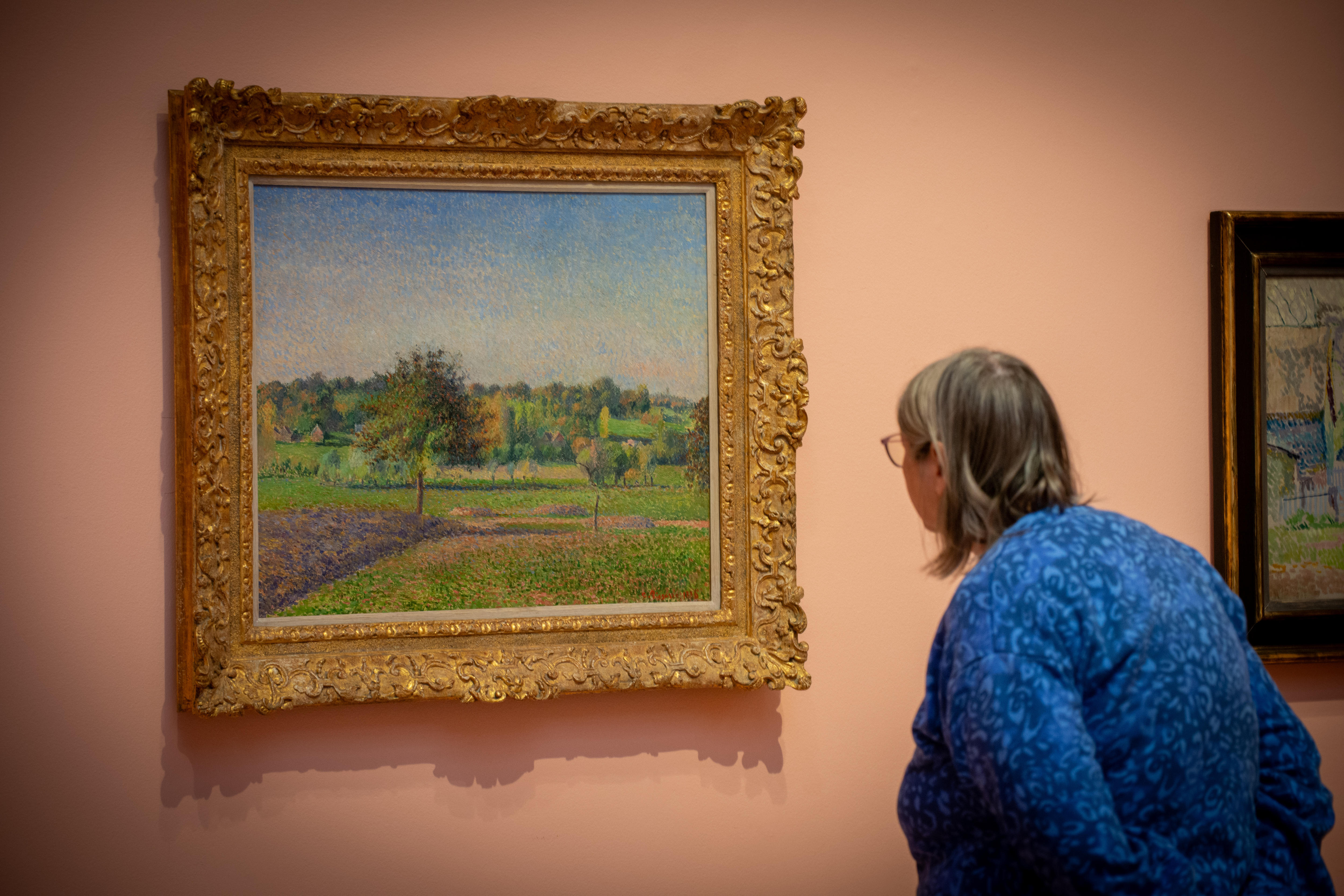 A woman leaning in to look at art on display at the Art Gallery of South Australia. 