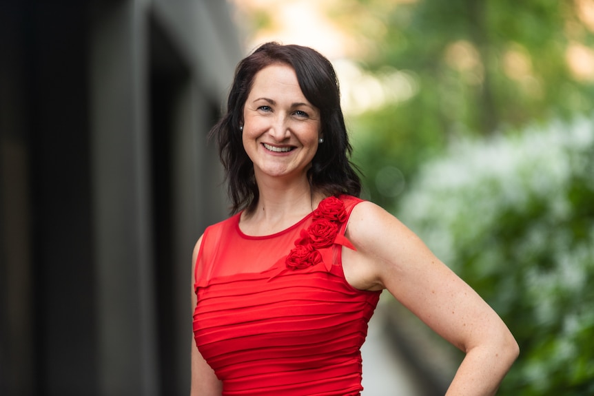 woman in red dress smiling at camera in standard professional headshot