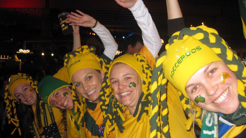Socceroos fans brave the early-morning elements at Sydney's Darling Harbour ahead of the Germany clash.