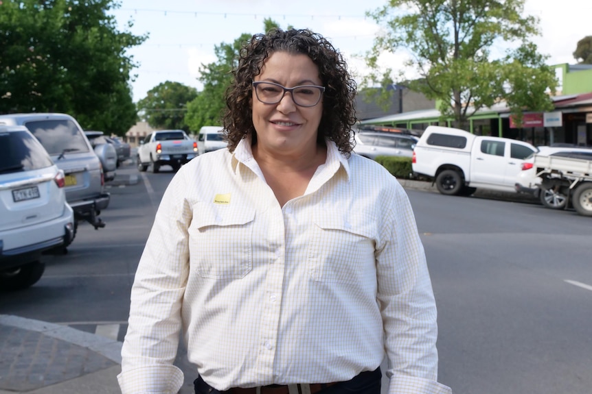 Woman in white shirt with Ray White logo on country town street