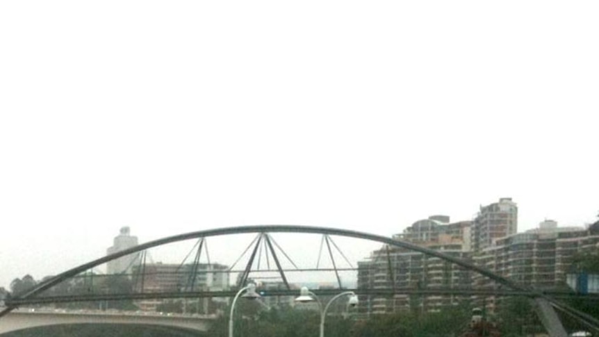 The Brisbane River swamps one of the ferry pontoons at South Bank