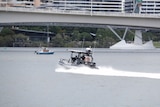 Water police boat scouring Brisbane River for missing man.