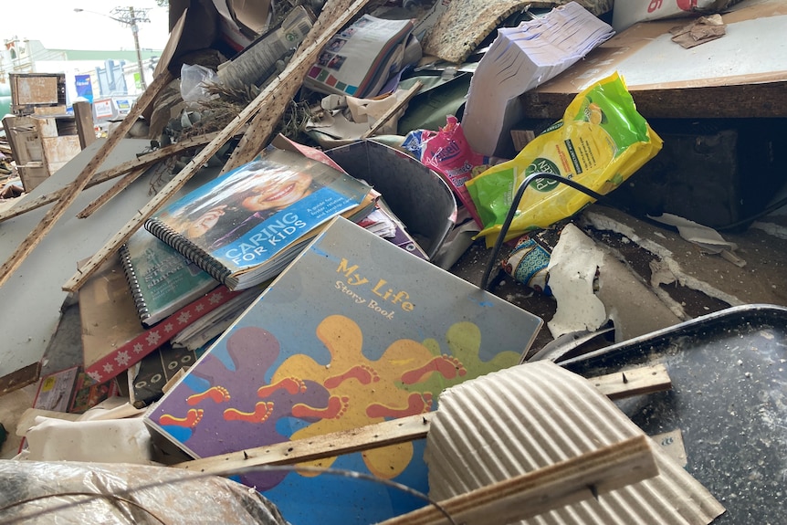 A pile of rubbish on a street with a book in the center that says 'My Life'