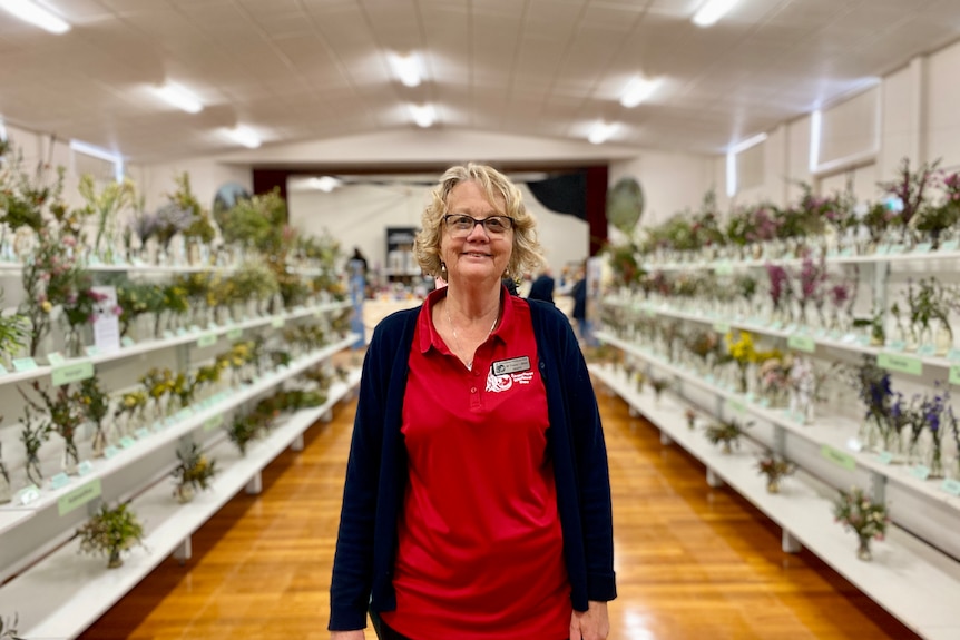 woman standing in middle of isle with wildflowers