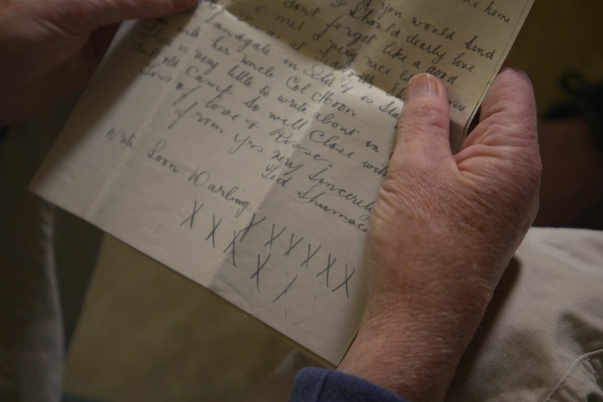 An old letter being held by a man's hand