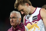 Brisbane Lions coach Chris Fagan talks to captain Harris Andrews as they walk off the field.