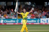 A cricketer raises her bat in one hand and her helmet in the other as he celebrates her century.