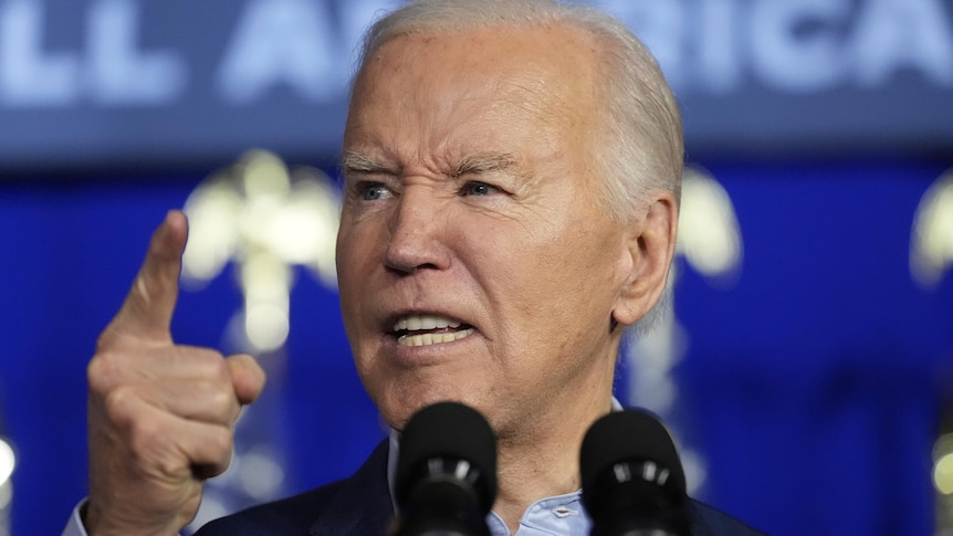 Joe Biden speaks into a microphone, looking angry and pointing a finger