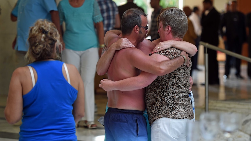 Tourists comfort each other after the mass shooting in the Tunisian resort town of Sousse.