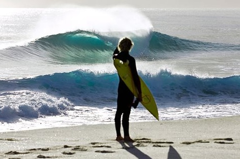 Lone surfer looks out to waves at Martha Lavinia Beach, King Island, Tasmania.