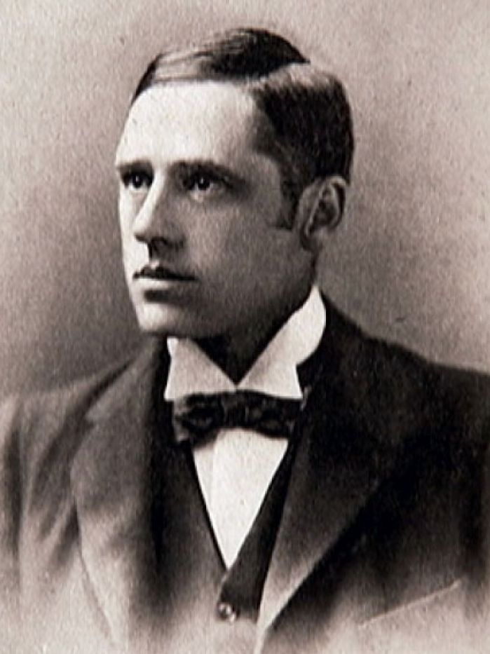 An historic sepia photo of a man wearing a suit.