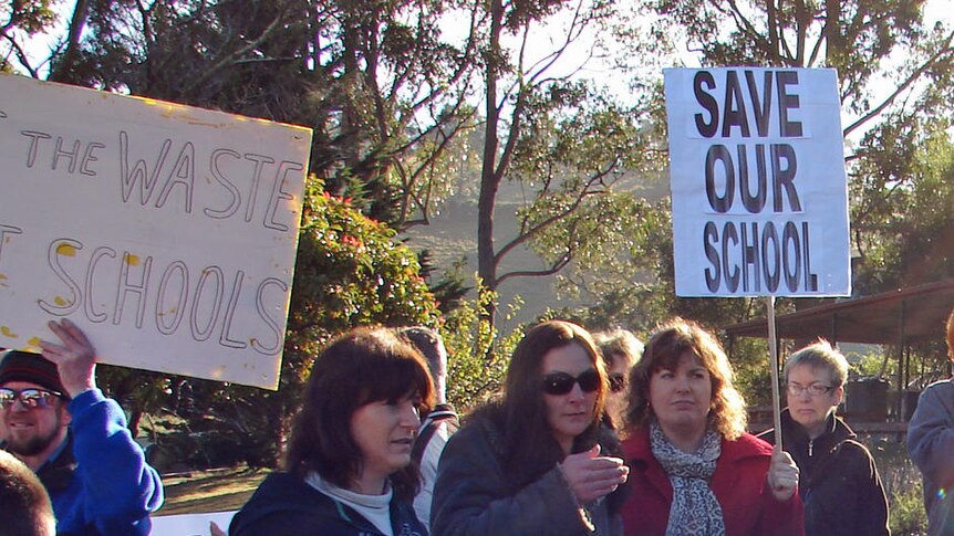 Collinsvale Primary School parents hold banners at a rally to keep the school open.