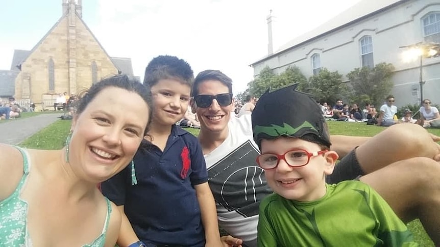 A selfie showing a family (mum and dad and their two young boys, all smiling)