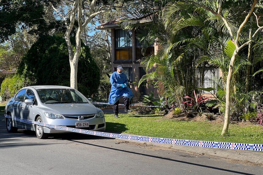 Police tape and a forensic officer outside Huni's home.