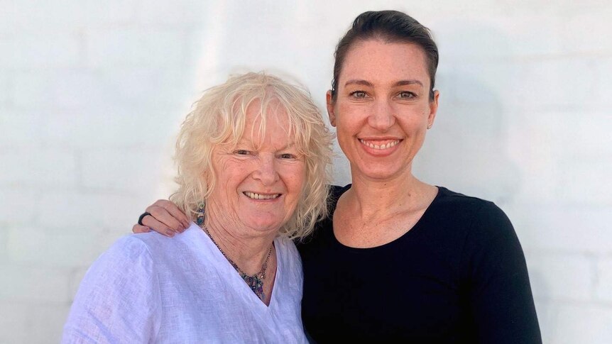 Tamara Oudyn (right) stands with her arm around a blond woman wearing a white shirt.