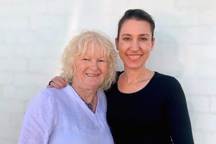 Tamara Oudyn (right) stands with her arm around a blond woman wearing a white shirt.