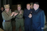 Kim Jong-un celebrates with North Korean ofiicials
