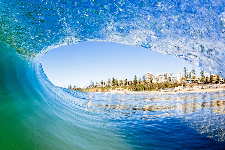 North Wollongong buildings are seen through a blue wave curling the top of the screen.