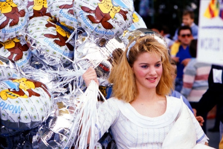 A woman holding balloons at Expo 88 in Brisbane