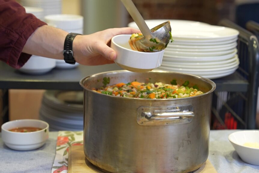 Large pot of soup being ladled into a bowl