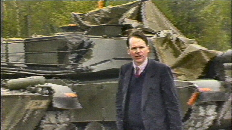 Mark Colvin in Germany in front of a tank