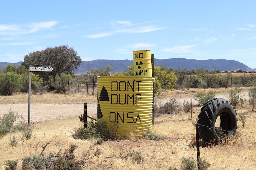 A yellow tank with "don't dump on SA" written on it at a road intersection.